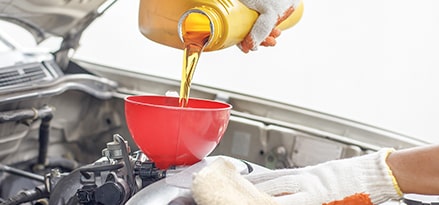 pouring oil into a funnel